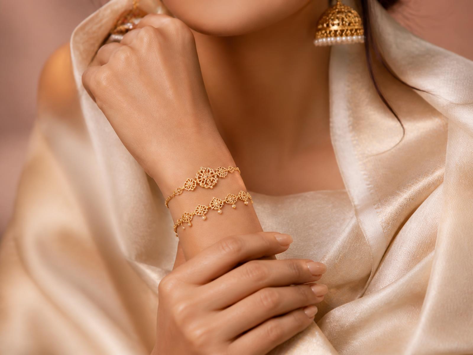 Gold filigree bracelets and jhumka earrings worn with ivory silk